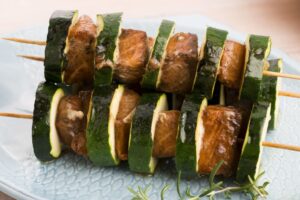 Rinderspieße mit Zucchini und grünem Salat